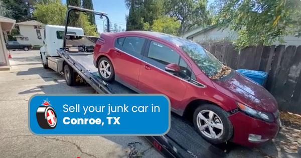 Junk car on a tow truck being removed in Conroe