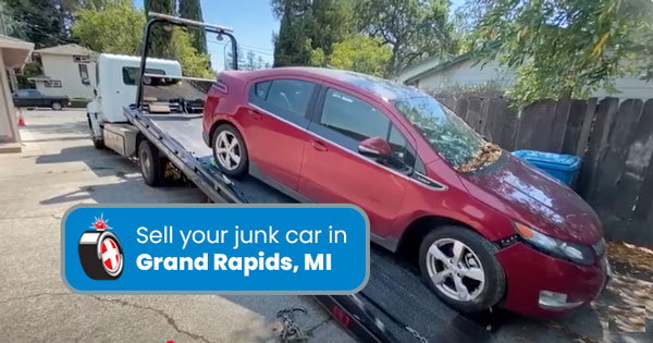 Junk car on a tow truck being removed in Grand Rapids