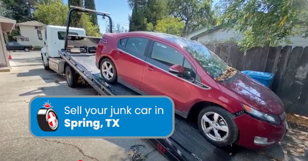 Junk car on a tow truck being removed in Spring