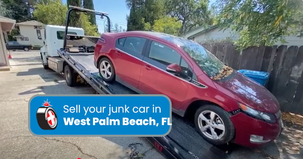 Junk car on a tow truck being removed in West Palm Beach